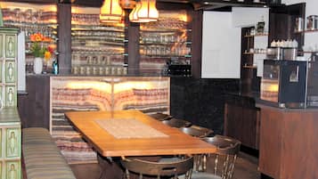 A bar area with a wooden table, chairs, and a bar counter.