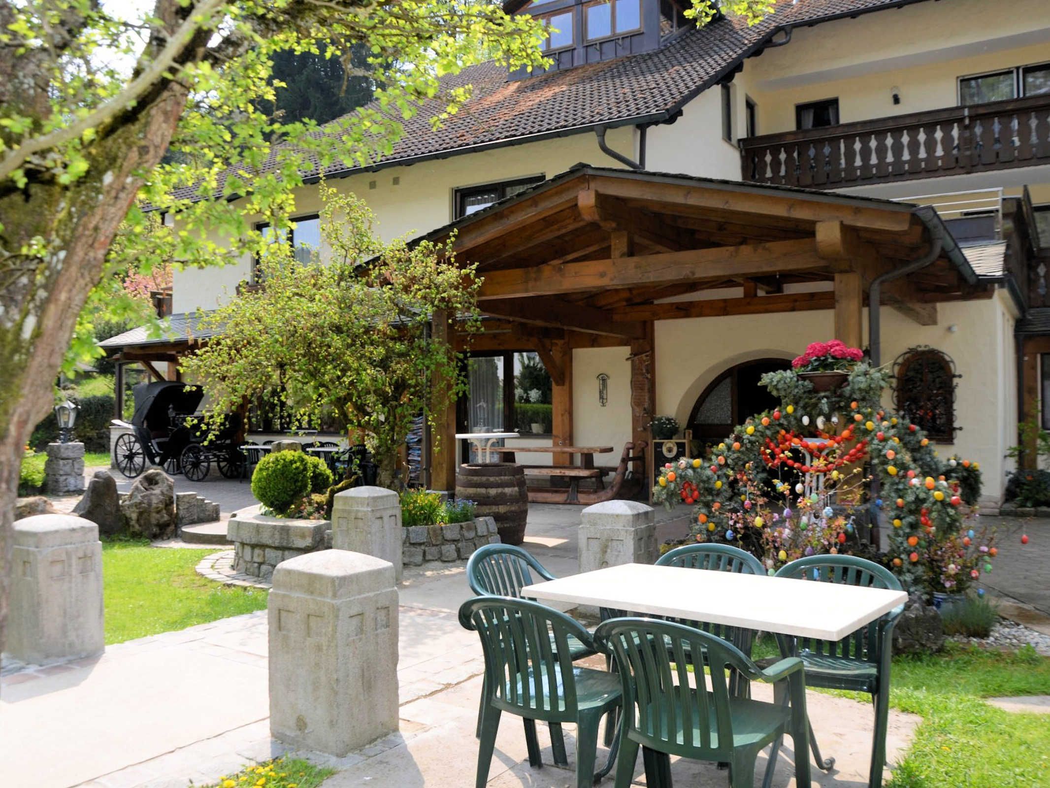 A patio area with a table and chairs, a covered seating area, and a decorative Christmas tree.