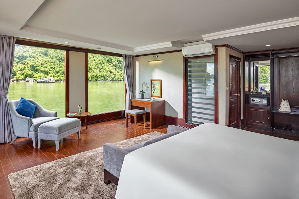 Une chambre d’hôtel avec un grand lit, un bureau, une chaise et une vue sur un lac.