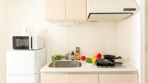A compact kitchen with a microwave, stove, sink, and cabinets.