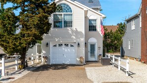 A two-story house with a white exterior, a garage, and a front yard with a white picket fence.