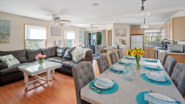 A modern living room with a sofa, coffee table, and dining area set for a meal.
