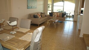 A spacious living room with a sofa, chairs, and a coffee table. There is a painting on the wall and a window providing natural light. - PENTHOUSE CONDO | BEAUTIFUL | 3 BEDS | 3 BATHS | 2 LEVELS | MAGNIFICENT VIEWS (Fajardo)