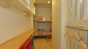 A narrow hallway with a wooden bench, a red storage unit, and a clothing rack. - Merveille Ueno House Tokyo (Tokyo)