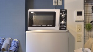 A kitchen with a microwave, a double-door refrigerator, and a fire extinguisher. - Merveille Ueno House Tokyo (Tokyo)