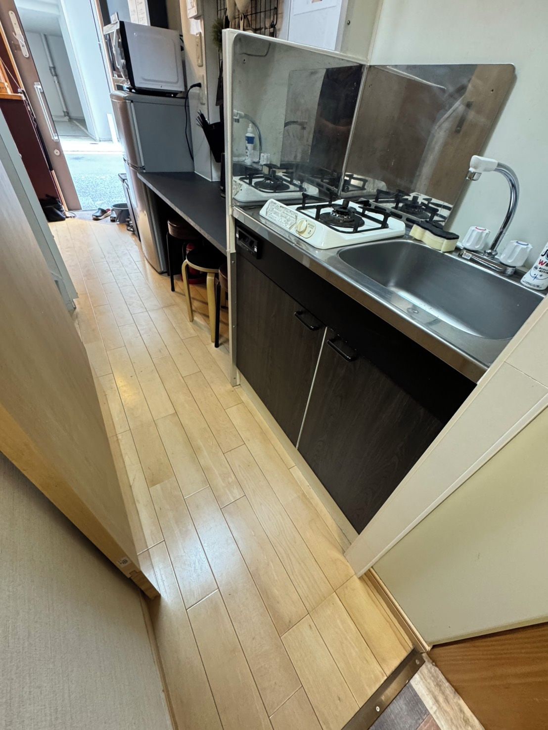 A compact kitchen with a gas stove, sink, and a dishwasher.