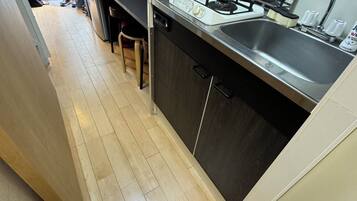 A compact kitchen with a gas stove, sink, and a dishwasher.