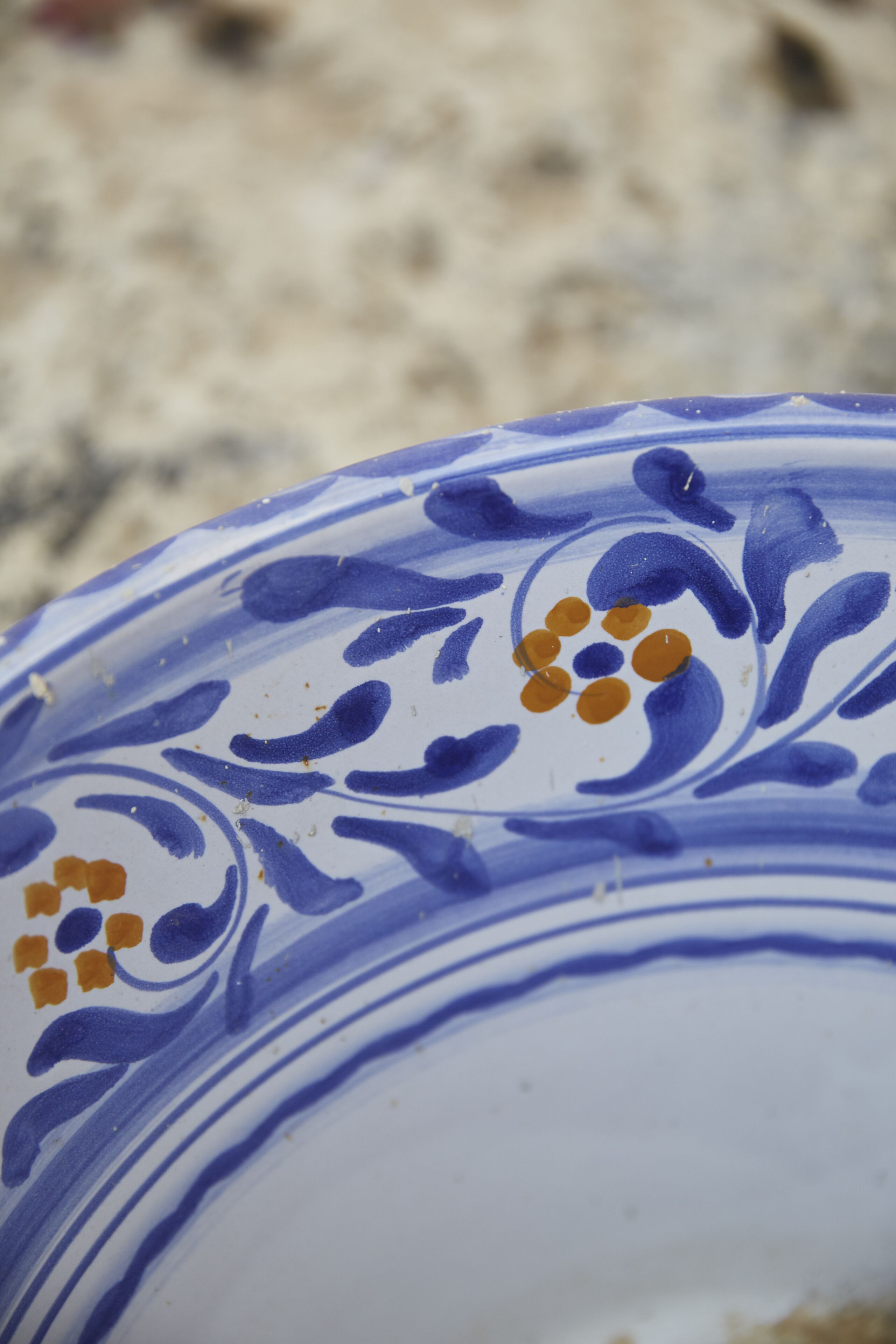 Un gros plan d’une assiette en céramique ornée de motifs bleus et orange.