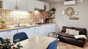 A compact kitchen with a dining area, a sofa, and a coffee machine. - 2 bedroom stunning home in Sisan (Sisan)