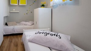 A bedroom with two beds, each with a pillow featuring a name. There are wall decorations, including butterflies and a plant. - 2 bedroom stunning home in Sisan (Sisan)