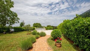 A garden pathway leading to a gated area with a swing chair and a play structure. - 2 bedroom stunning home in Sisan (Sisan)