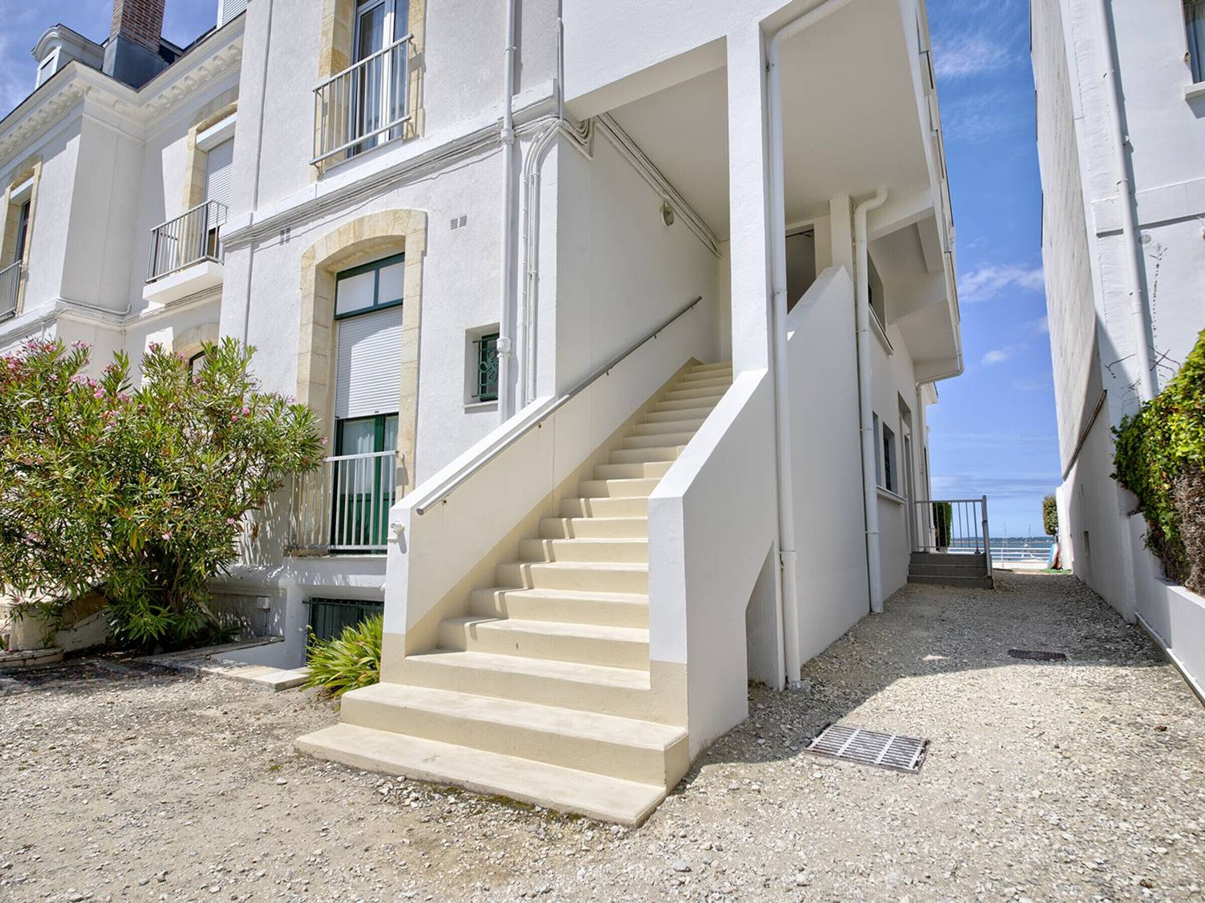 A white building with a central staircase leading to a second floor.