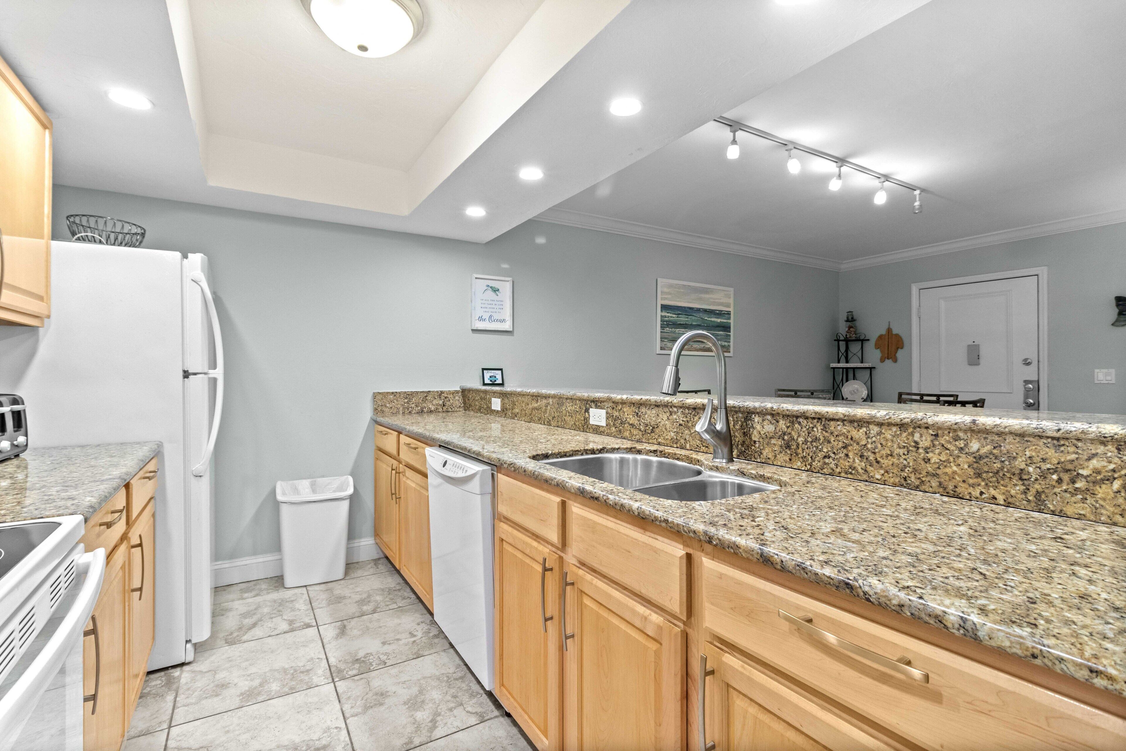 A modern kitchen with granite countertops, stainless steel appliances, and wooden cabinets.