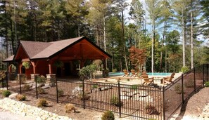 A lodge with a covered patio, a swimming pool, and a fenced outdoor area. - Lake James Waterfront with Dock, Pool, Kayaks and Paddle Boards! (Nebo)