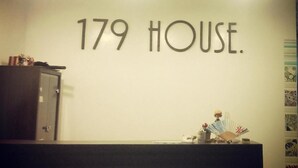 Ein Empfangsschalter mit einem Schild, auf dem '179 HOUSE' steht.