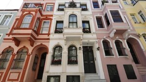 Une rangée d’immeubles à étages, chacun ayant un style architectural distinct et doté de balcons.