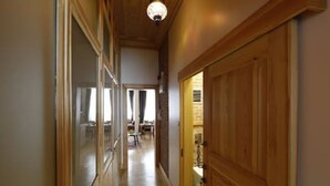Un couloir avec des portes en bois et un luminaire au plafond.