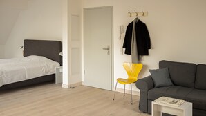 Une chambre moderne avec un lit, un canapé, une petite table et une chaise.