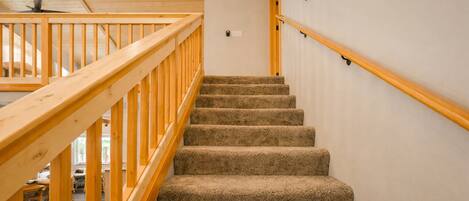 A wooden staircase with carpeted steps leading to a landing.