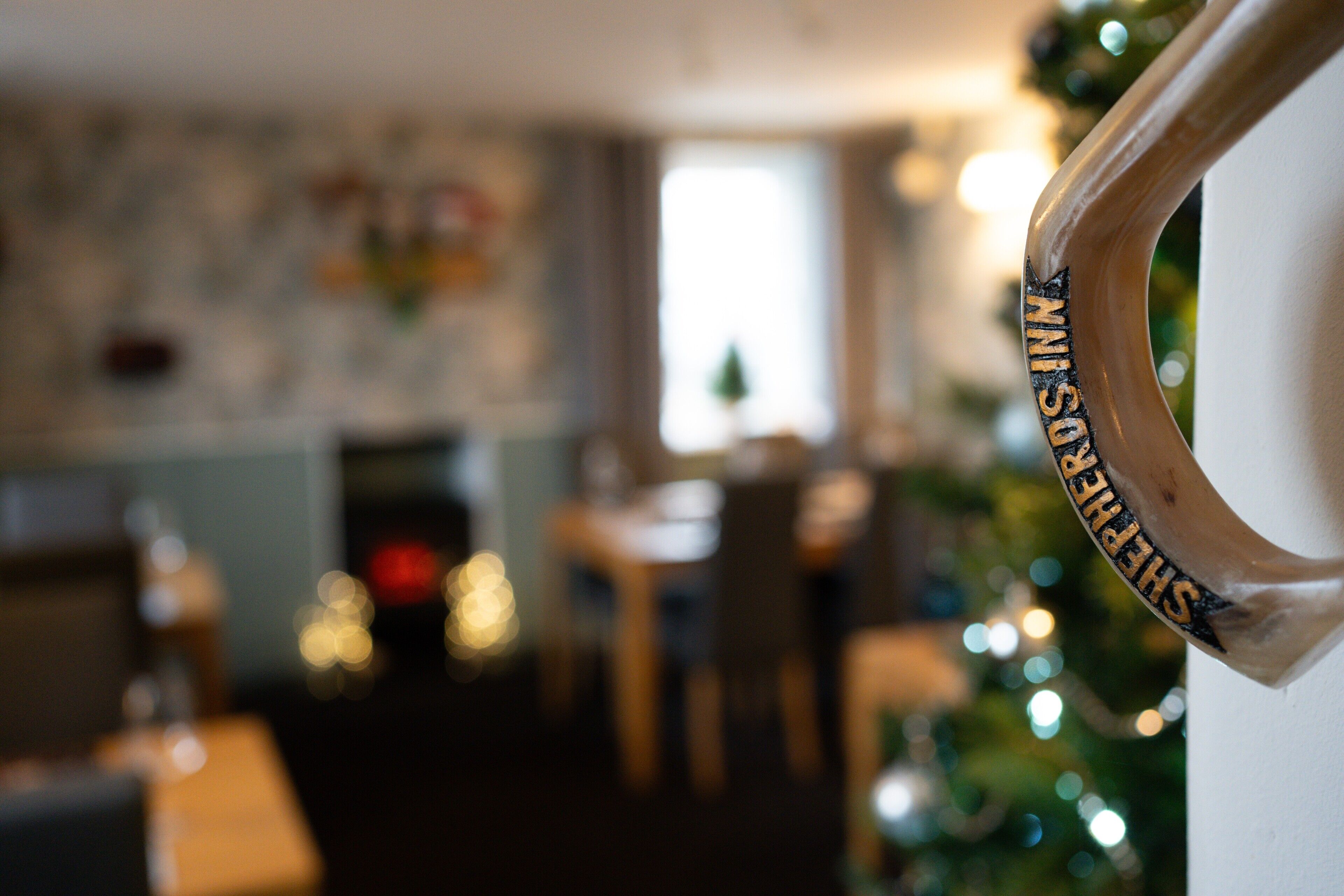 Ambiente interior borroso con un árbol de Navidad y un cartel que dice 'SANTA'S HOUSE'.