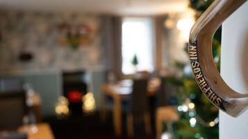 Ambiente interior borroso con un árbol de Navidad y un cartel que dice 'SANTA'S HOUSE'.