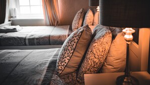 A hotel room with a bed, pillows, a nightstand, and a lamp. - The Shepherds Inn (Penrith)