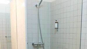 A bathroom with a glass-enclosed shower, a sink, and a toilet.