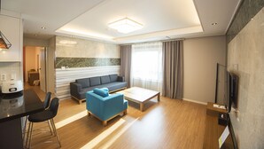 A modern living room with a sofa, coffee table, and TV stand.