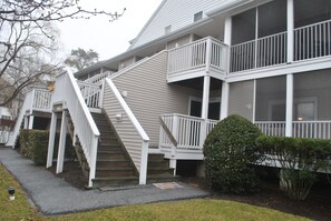 A two-story house with a front porch, a staircase, and a small garden area. - Privacy, Lakefront, and Sea Colony = A memorable vacation! (Bethany Beach)
