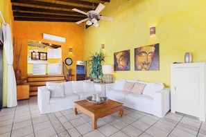 A living room with a white sofa, a wooden coffee table, and a ceiling fan.