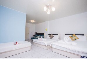 Habitación de hotel con dos camas individuales, una mesita y una silla.
