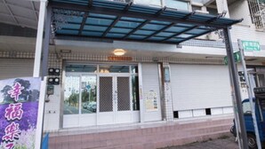 A multi-story building with a covered entrance and a signboard.
