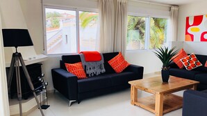 A modern living room with a black sofa, a wooden coffee table, and a tripod lamp. - Stunning Detached 3 Bedroom Villa with Private Pool and Sea View  (Peñíscola)