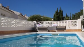 A swimming pool with lounge chairs and a white lattice fence. - Stunning Detached 3 Bedroom Villa with Private Pool and Sea View  (Peñíscola)