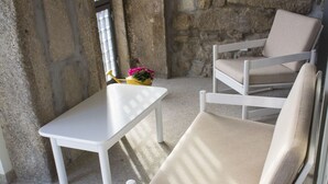 Un espace détente comprenant une chaise blanche, une petite table et un banc.