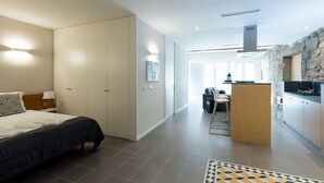 Une chambre d’hôtel moderne équipée d’un lit, d’un bureau et d’une kitchenette.