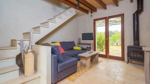A living room with a sofa, a television, a fireplace, and a staircase. - CAN PINA - ECO REDONDA 2 - Apartment with shared pool in Costitx. Free WiFi (Costitx)