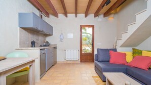 A compact living space with a kitchen, dining area, and a sofa with colorful cushions. - CAN PINA - ECO REDONDA 2 - Apartment with shared pool in Costitx. Free WiFi (Costitx)