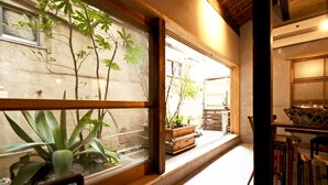 Una habitación con un amplio ventanal, suelo de madera y una estantería empotrada.
