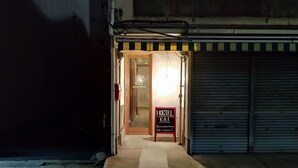 Entrada a un hostal con un cartel que indica que acepta huéspedes sin reserva.