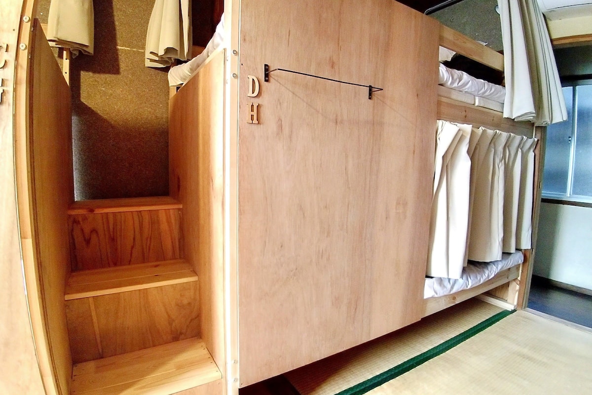 Una cama nido de madera con una pequeña escalera de madera y un estante sencillo.