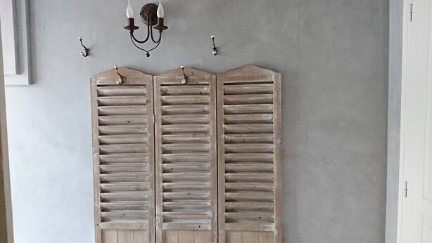 A room with a grey wall, a double wooden door with horizontal slats, and a wall-mounted light fixture above it. - country holiday home - in Champagne - Trélou sur Marne (Trélou-Sur-Marne)