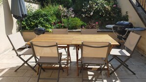 A wooden table with four chairs, a grill, and a garden with various plants and flowers. - country holiday home - in Champagne - Trélou sur Marne (Trélou-Sur-Marne)