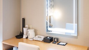 A hotel room with a wooden desk, a white telephone, a black clock, a tissue box, a black remote control, and a white coffee maker. - Hotel Axia Inn Osaka Uehonmachi (Osaka)
