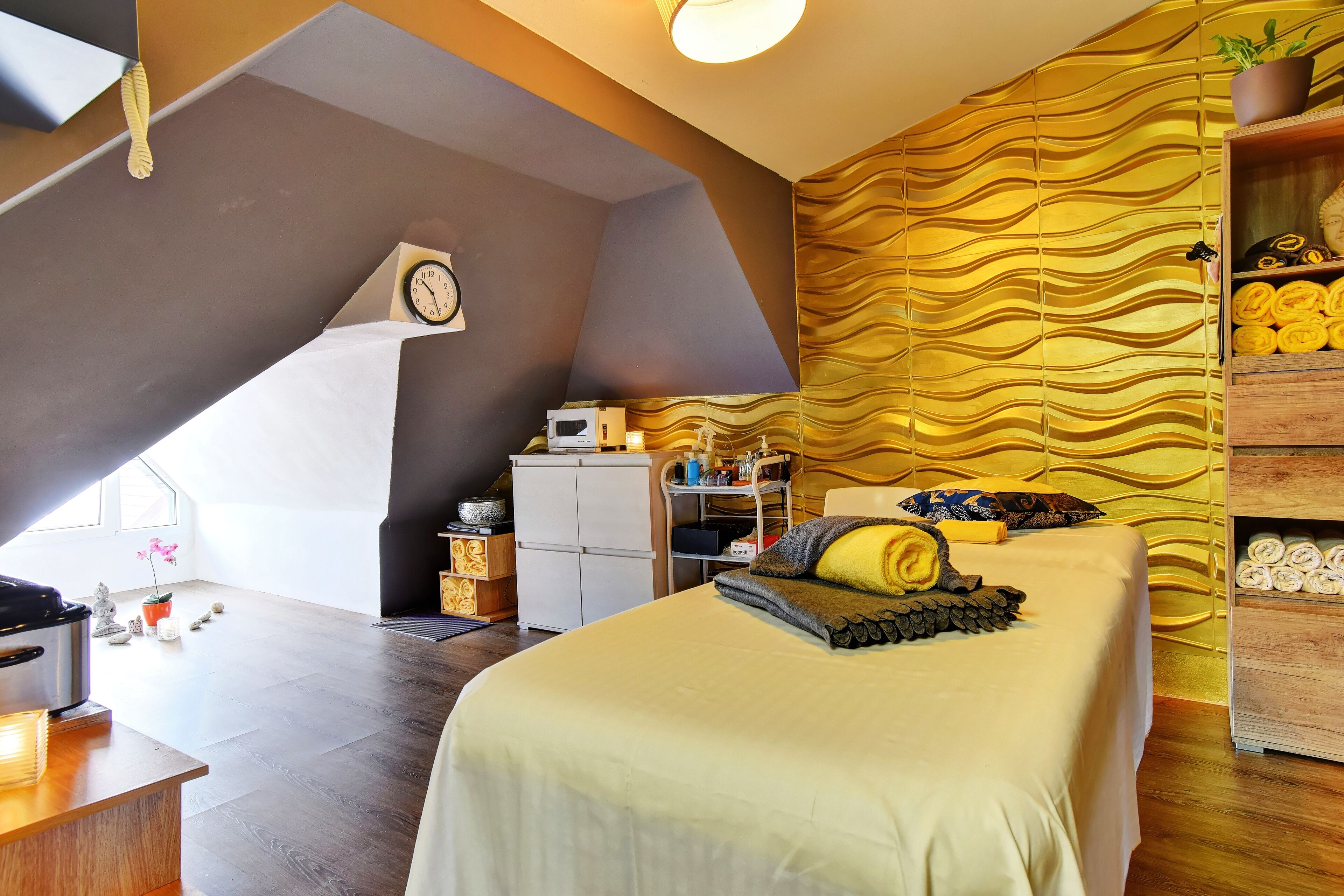 Un dormitorio con cama, escritorio, microondas, armario y un papel tapiz estampado.