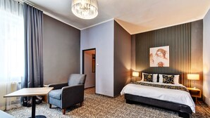 A hotel room with a bed, a chair, a table, and a lamp. - Hotel DaVinci (Marianske Lazne)
