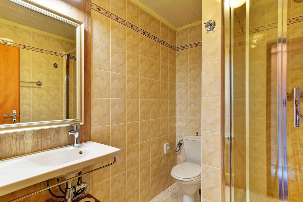 A bathroom with a sink, toilet, and glass shower enclosure.