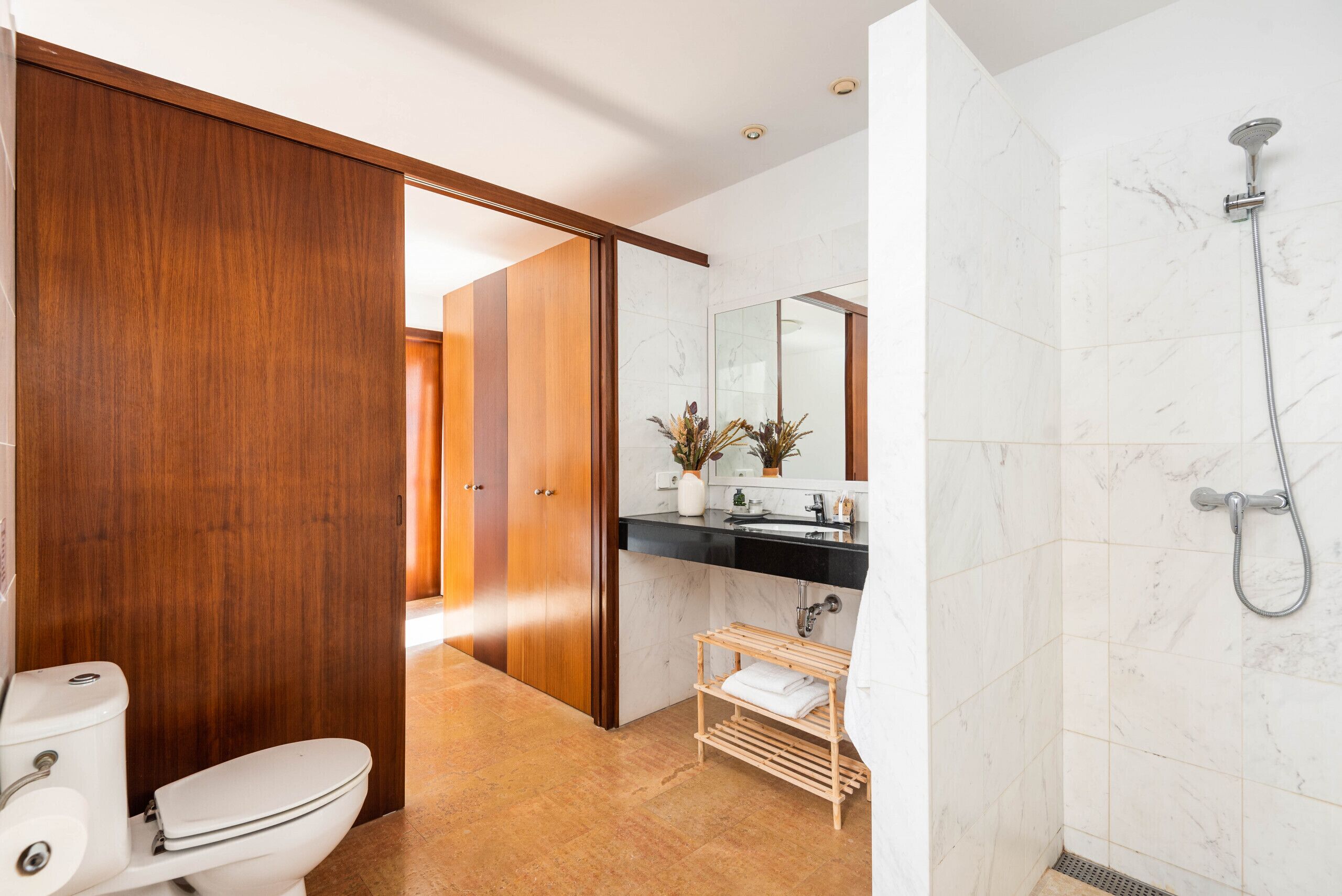 A modern bathroom with a toilet, sink, and shower.