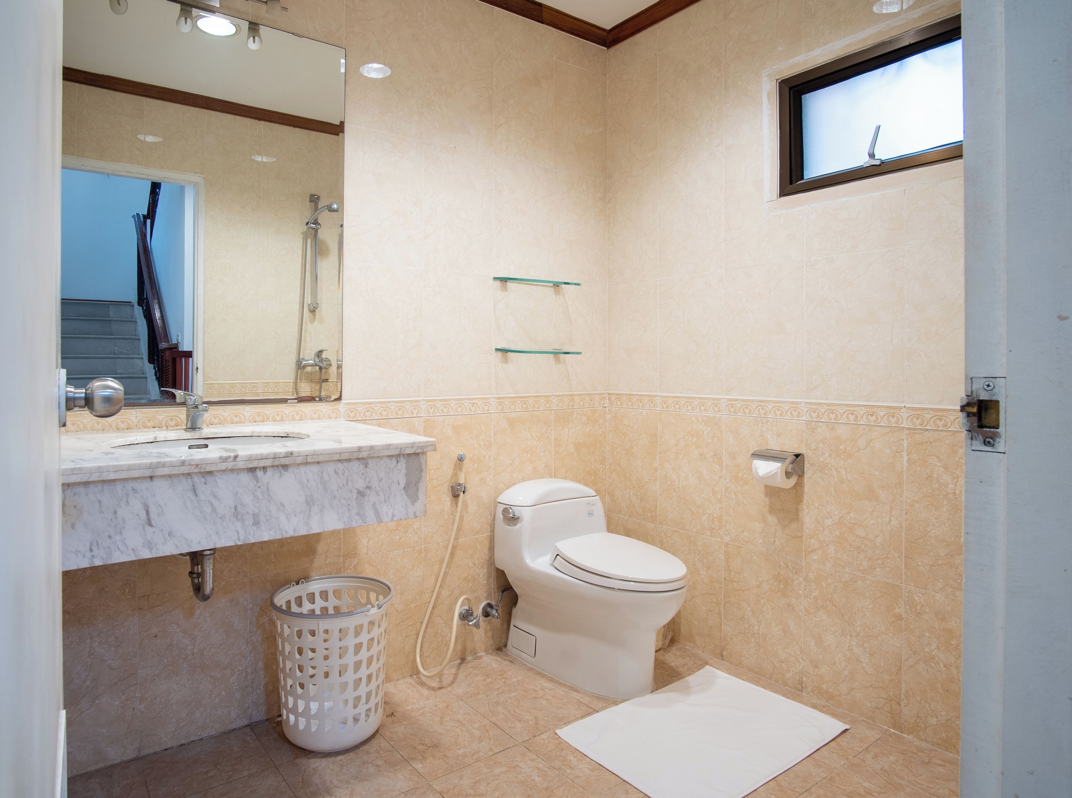 Une salle de bain avec un lavabo en marbre, des toilettes et une douche.