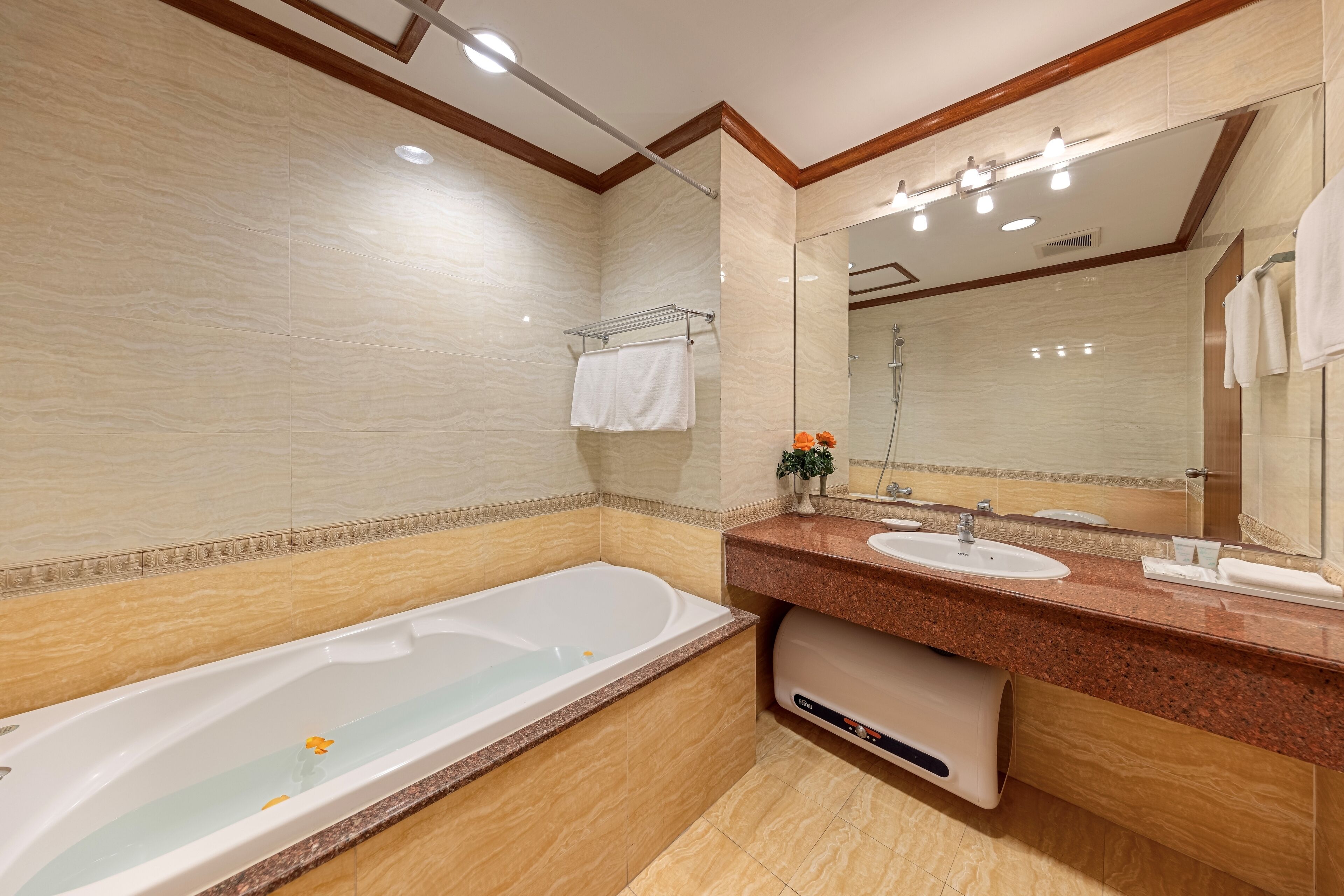 Une salle de bain moderne avec une grande baignoire, un meuble-lavabo à deux vasques et un grand miroir.